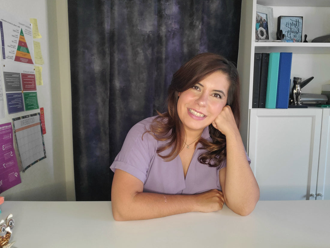 A portrait of Yana, founder of Unclear Perfection, sitting at the work desk.